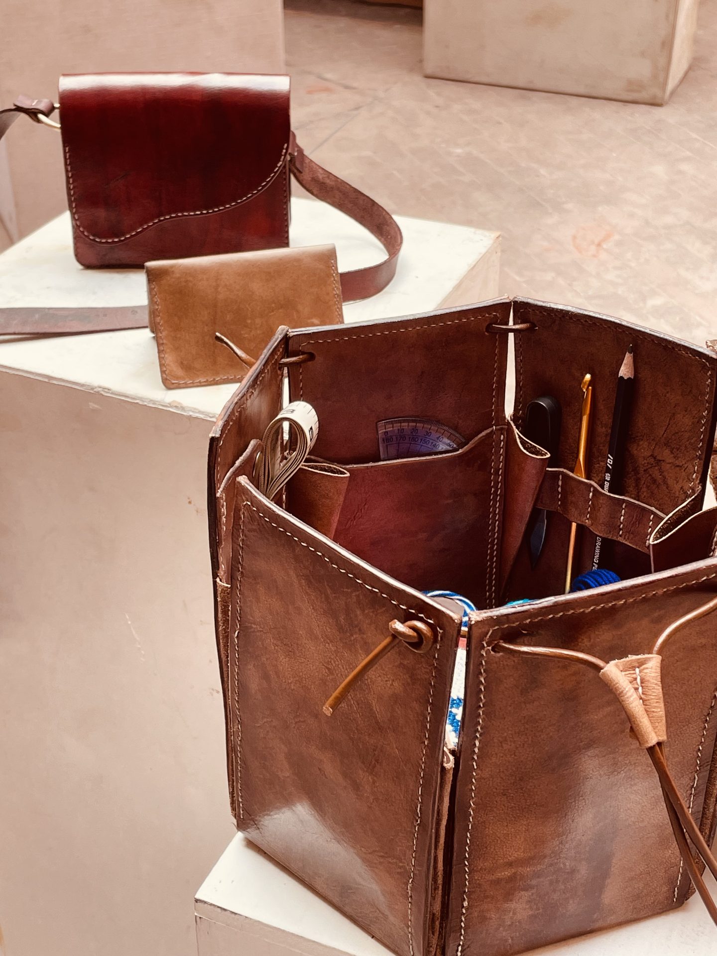 Final leather collection displayed on plinths