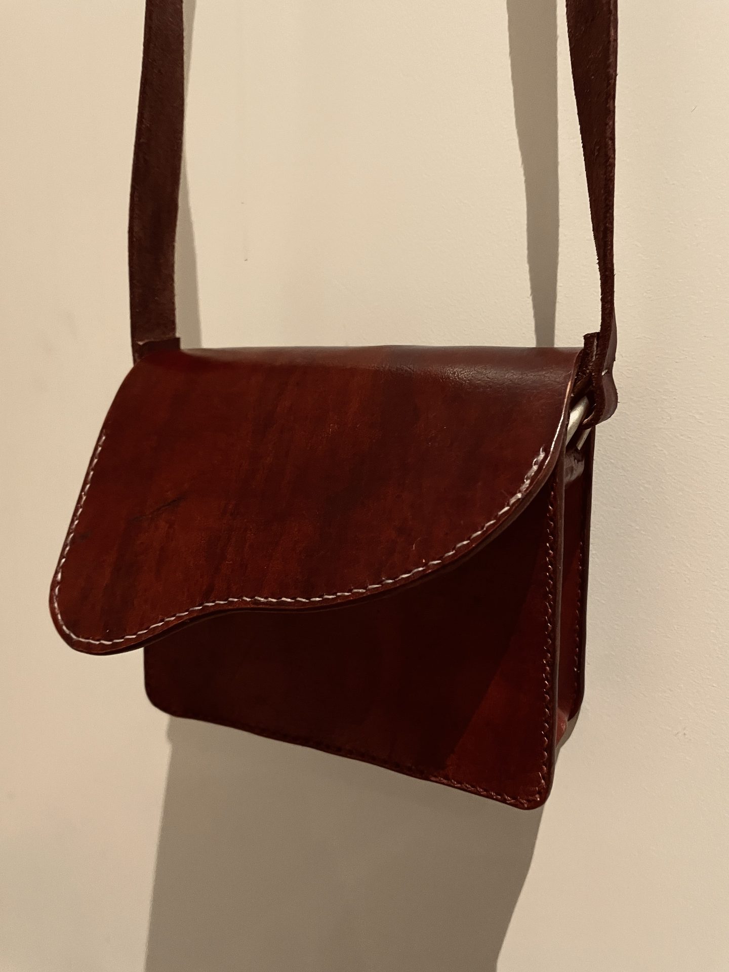 Mahogany leather crossbody saddle bag, side profile