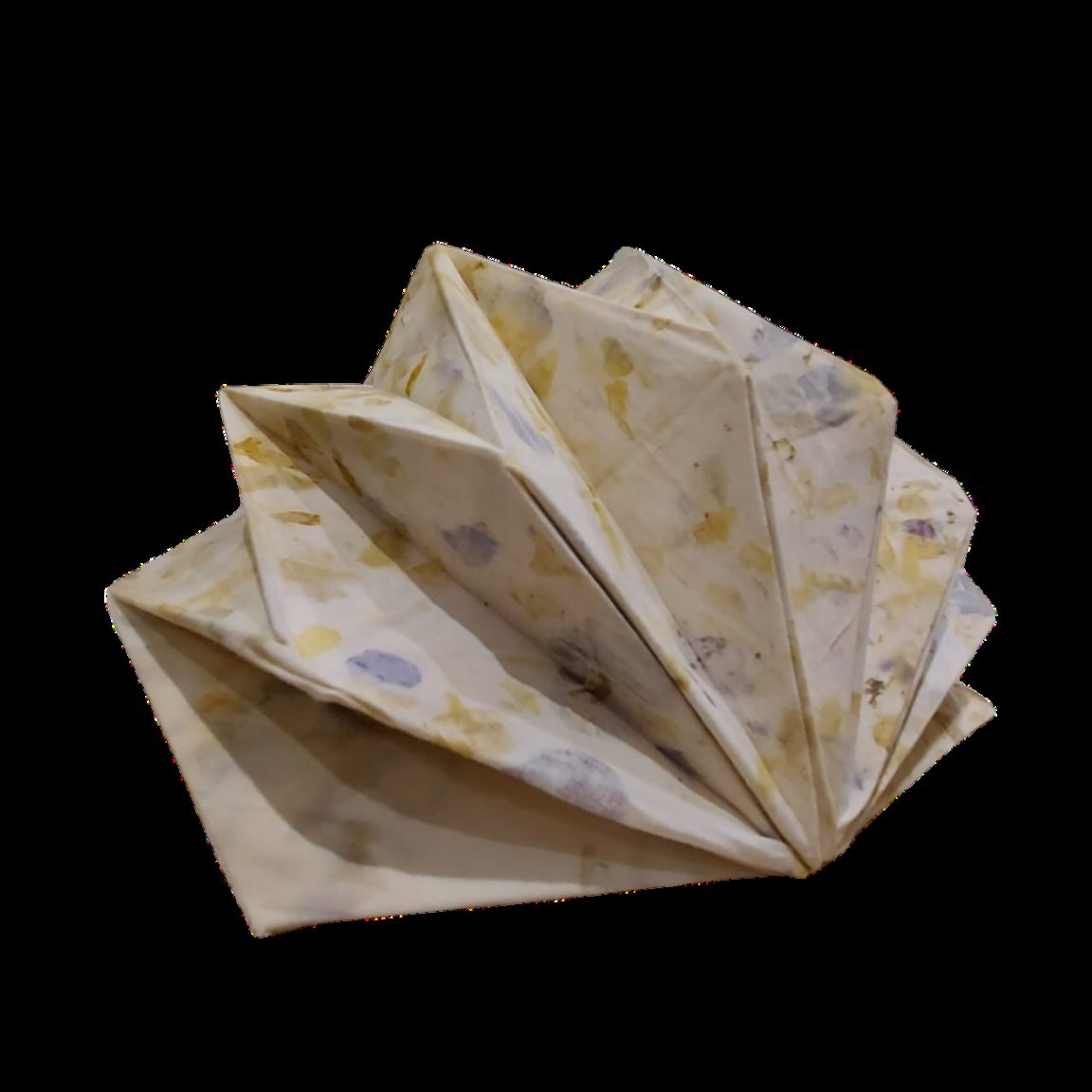 Open eco-printed folded form against a black background